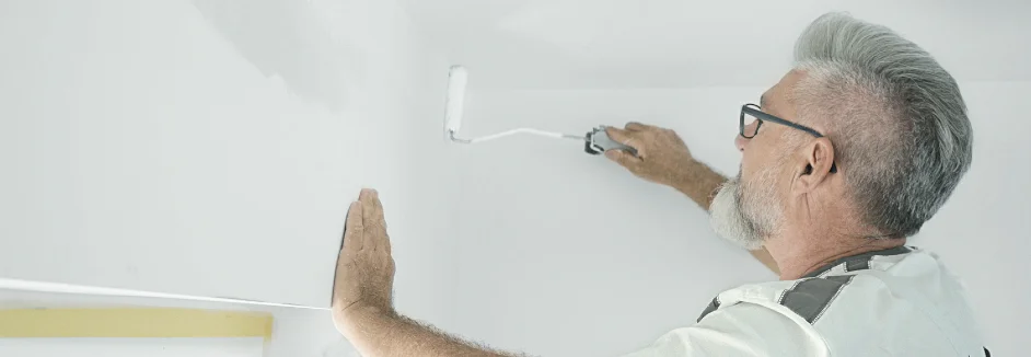 Person streicht Wand weiß